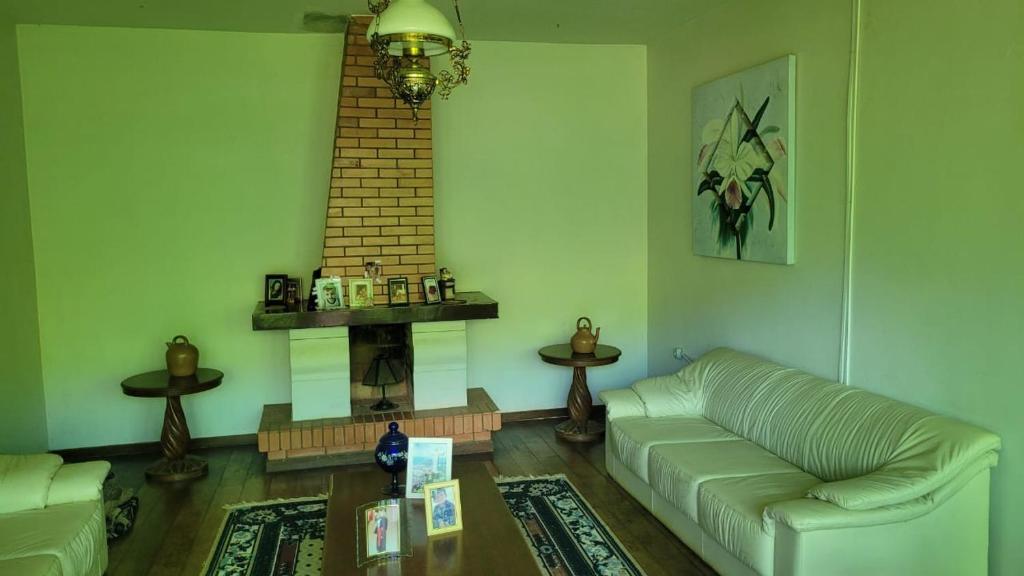 a living room with a couch and a fireplace at Pousada Serrana in Coimbra