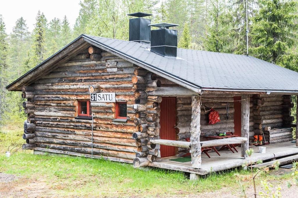 SyöteにあるSatu 31, kahden makuuhuoneen kelomökki Syötteellä, valaistun ladun vieressäの目の前に看板が書かれたログキャビン