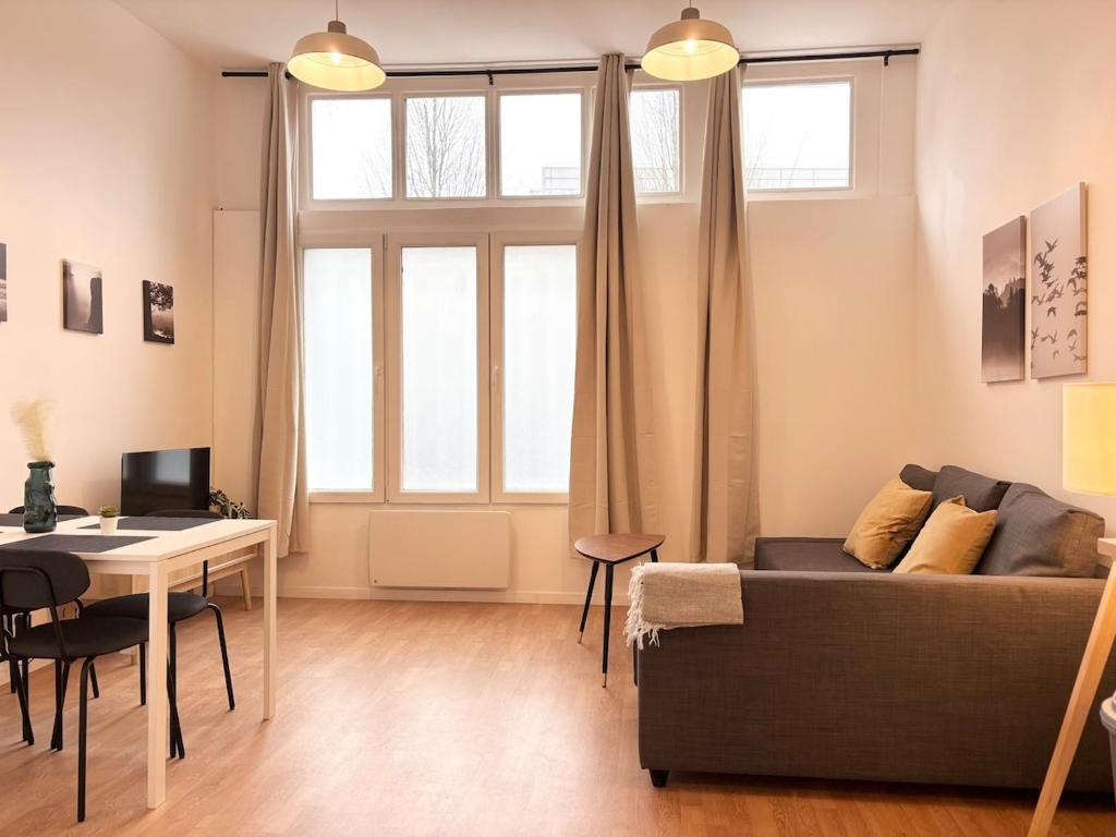 un salon avec un canapé et une table dans l'établissement Lovely apartment - 4 guests Roubaix, à Roubaix