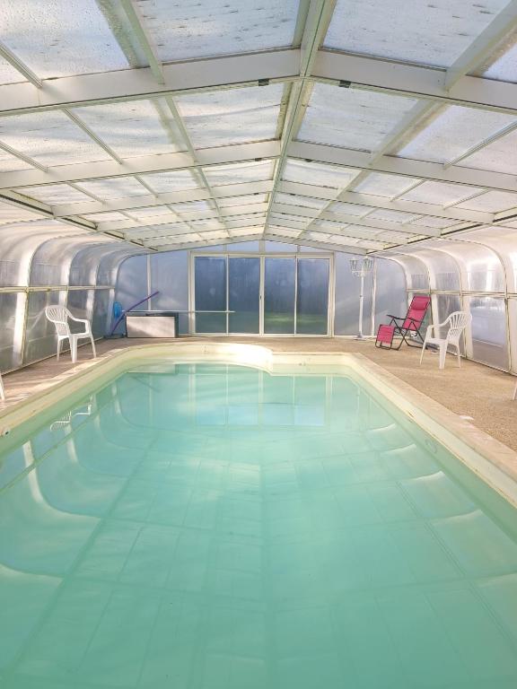 - une grande piscine avec 2 chaises dans une chambre dans l'établissement La Casa - Gîte familal - 15min from Puy duFou, à Mauléon