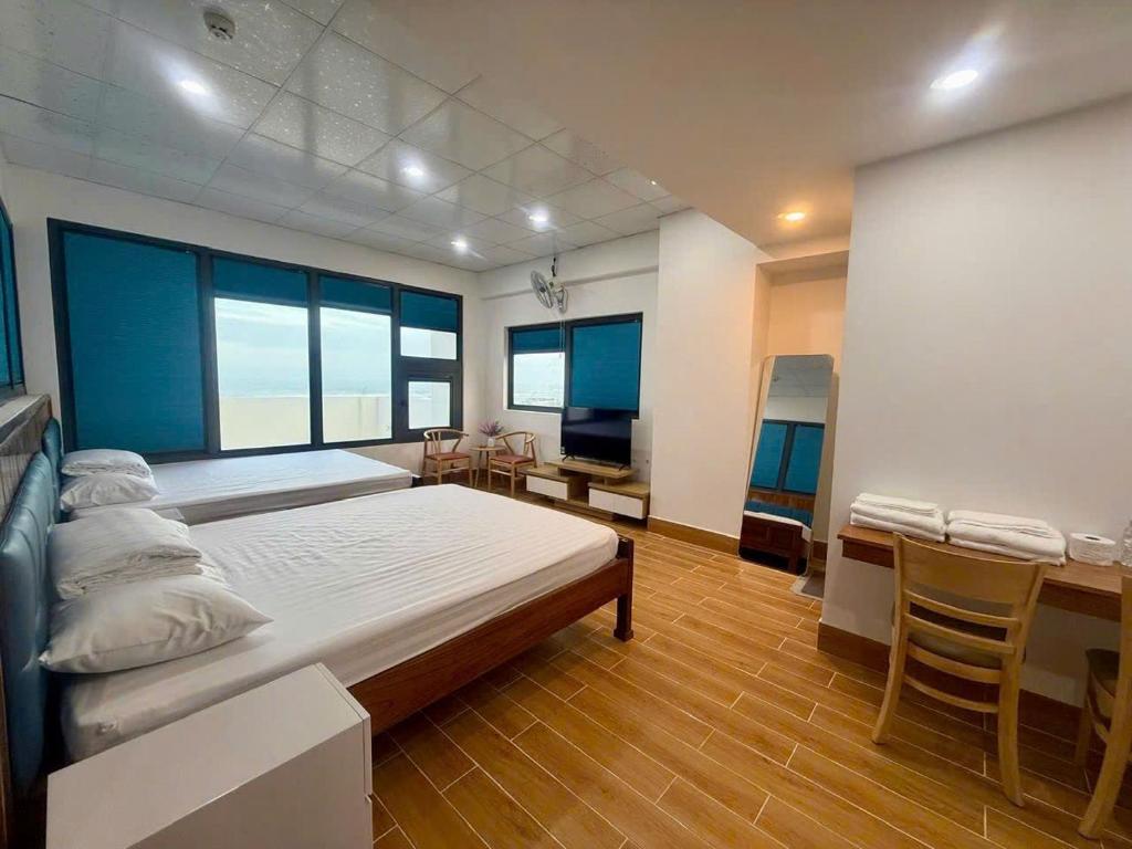 a bedroom with a large bed and a desk and chairs at Nhà nghỉ Bình An in Ðông Tác (1)