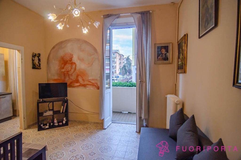 a living room with a blue couch and a window at La Magnolia del Ducato in Parma
