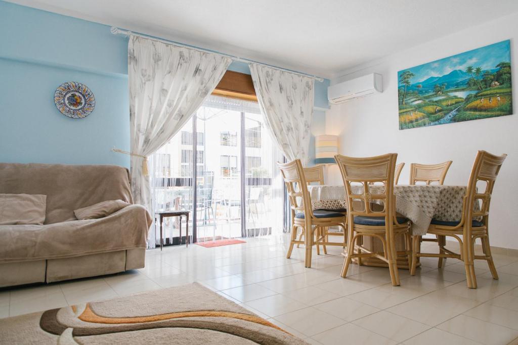 a living room with a couch and a table and chairs at Dona Ana Beach Apartment in Lagos