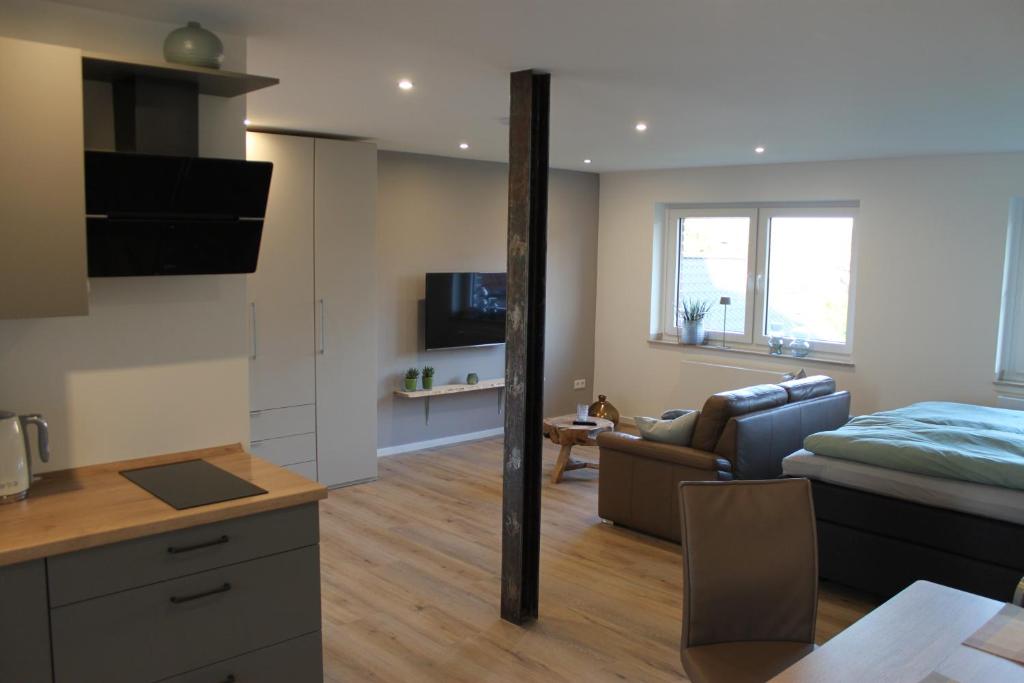 a kitchen and living room with a couch and a bed at Ferienwohnung Walgernheide in Warendorf