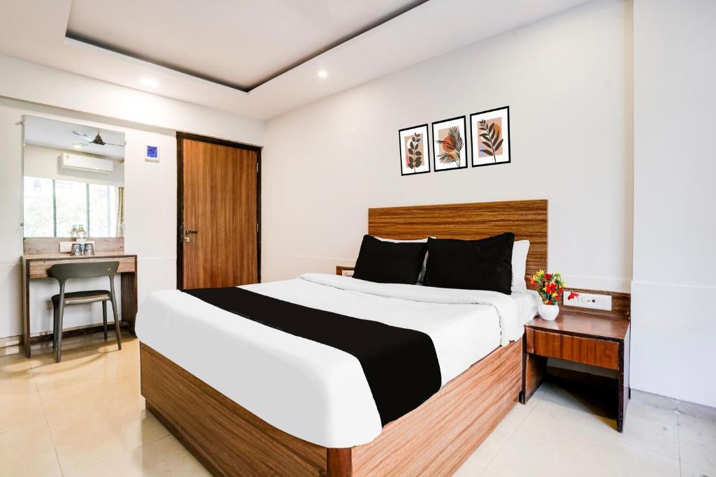 a bedroom with a large bed and a desk at Super Townhouse Marol Near Mumbai Airport in Mumbai