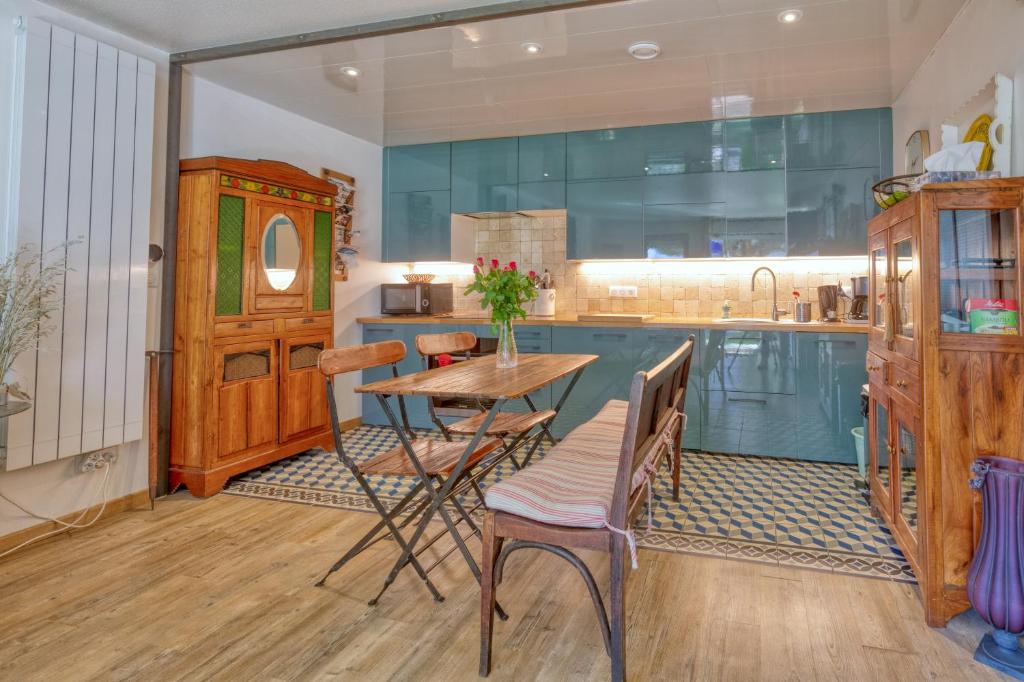 une cuisine avec des armoires bleues et une table et des chaises dans l'établissement Appart-terrasse , 80m de la plage Benoît, La BAULE, à La Baule