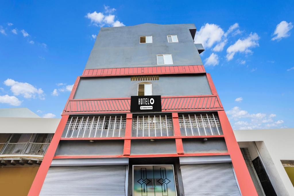 a tall red building with a sign on it at Super Hotel O Upper Bazar formerly RR Residency in Rānchī