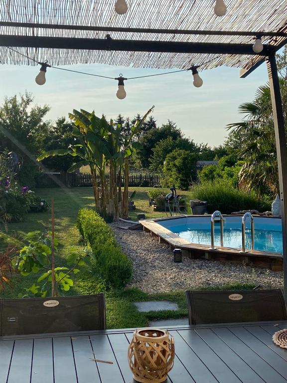 une cour avec une piscine et une pergola dans l'établissement Ferme, à Tavaux