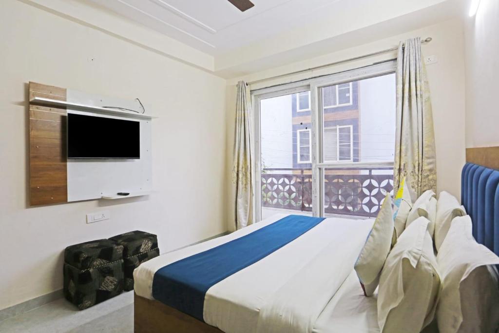 a bedroom with a bed and a large window at Cozy stay- A Home Away From Home in Gurgaon