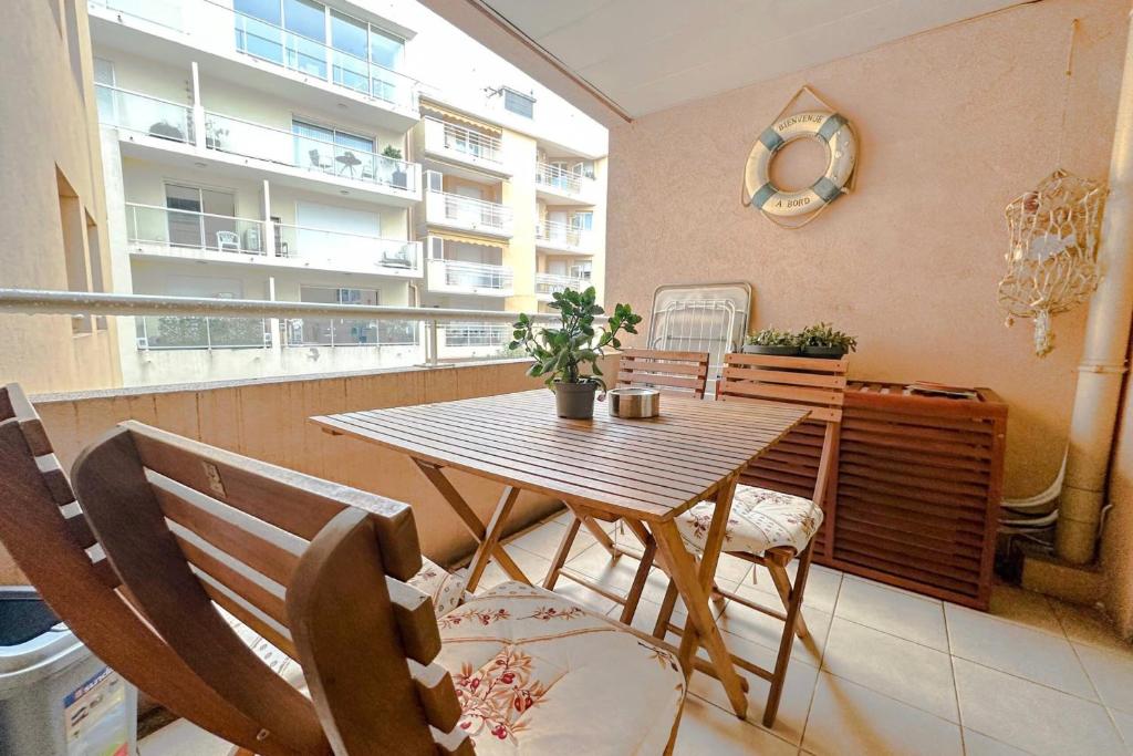 d'une table et de chaises en bois sur un balcon avec une fenêtre. dans l'établissement Charming T2 near the Port Vauban d'Antibes, à Antibes