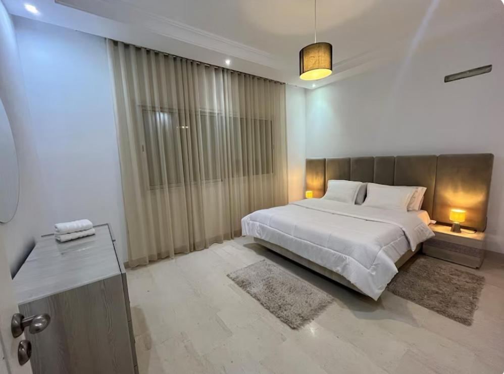 a bedroom with a large bed and a large window at Charmant appartement à Tunis ! in Tunis