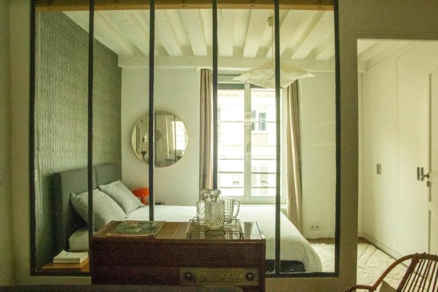 un miroir dans une chambre avec un lit et une table dans l'établissement Loft parisien au coeur du marais, à Paris