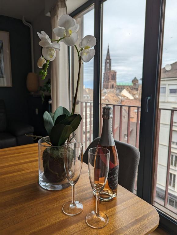 - une table avec une bouteille de champagne et 2 verres dans l'établissement Beautiful 3-room apartment with Cathedral view, à Strasbourg