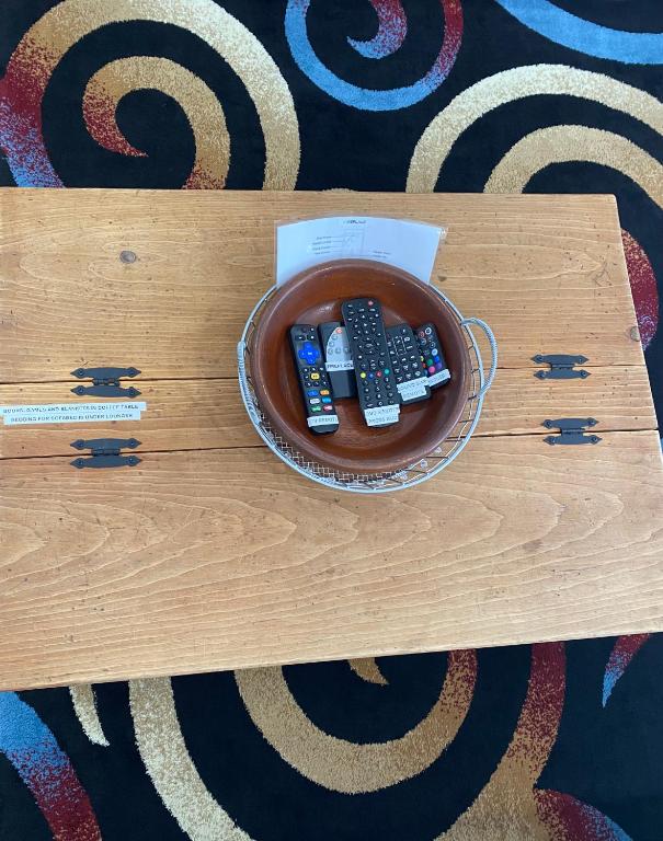 a bowl with three remote controls on a table at Our Place Up North BnB in Huntsville