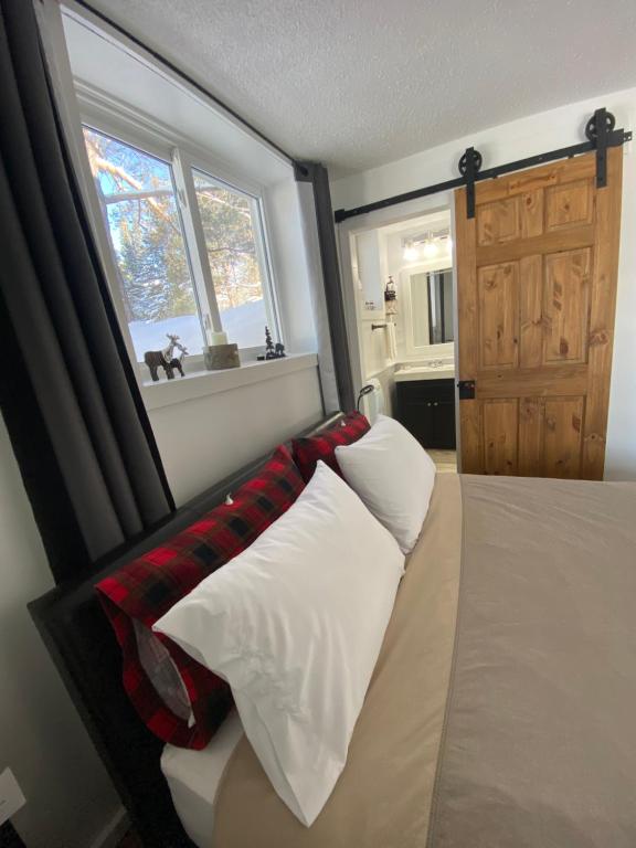 a bedroom with a bed with pillows and a window at Our Place Up North BnB in Huntsville
