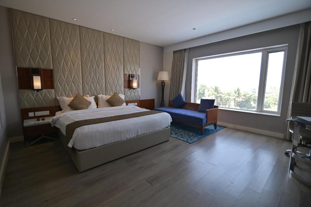 MandyaHotel Amaravathi的有一张大床和一扇窗户的酒店房间