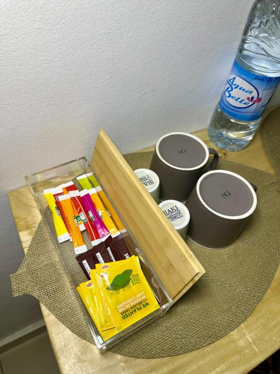 ein Tisch mit einem Tablett mit Schreibwaren und zwei Tassen in der Unterkunft Il Nido Cotonou in Cotonou