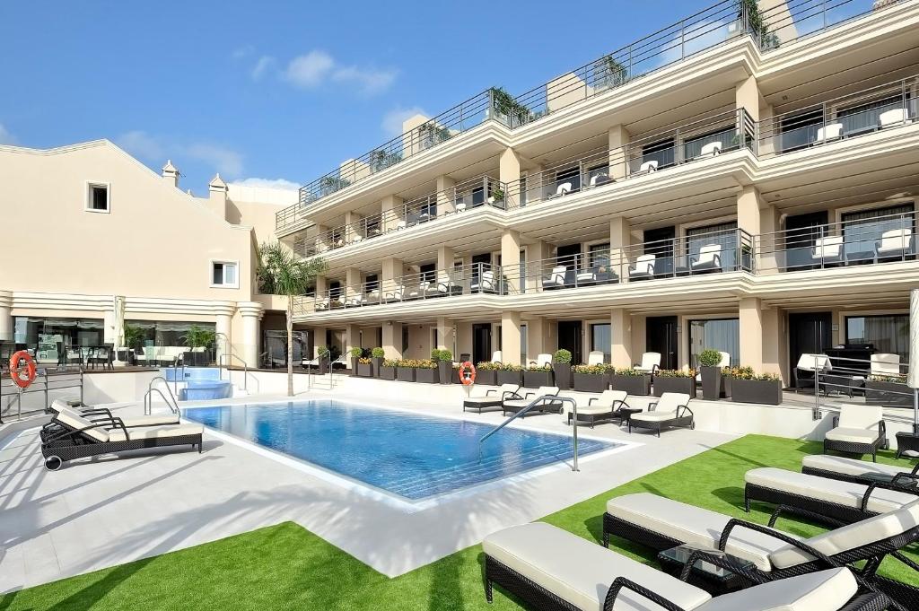 ein Hotel mit einem Pool und Liegestühlen in der Unterkunft Vincci Selección Aleysa in Benalmádena