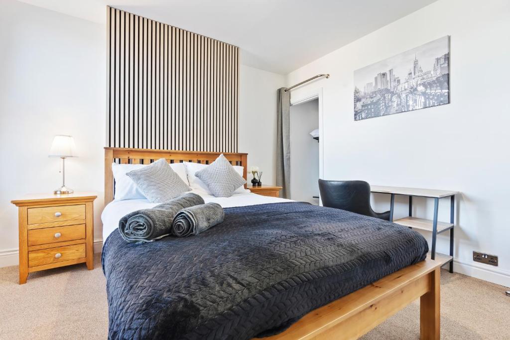 a bedroom with a large bed and a chair at Wolverhampton Townhouse - 3BR - Business & Leisure guests in Wolverhampton