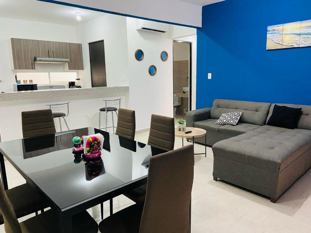 a kitchen and living room with a table and a couch at Depa en Cancun con alberca in Cancún