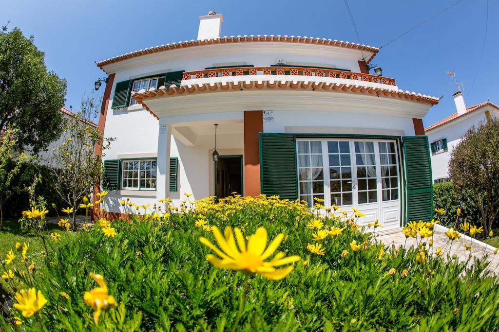a house with flowers in front of it at Liv In by Ericeira Property in Santo Isidoro