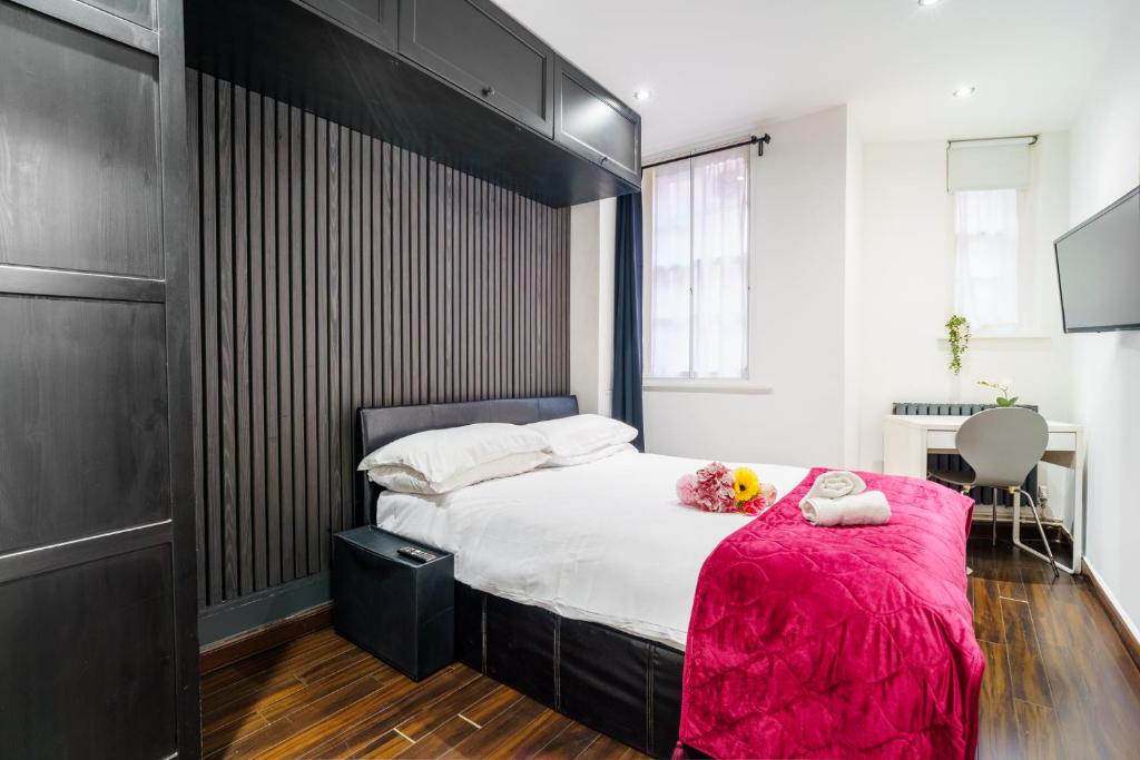 ein Schlafzimmer mit einem großen Bett mit einer rosa Decke in der Unterkunft Stylish 2 bedroom apartment in Shoreditch - London in London