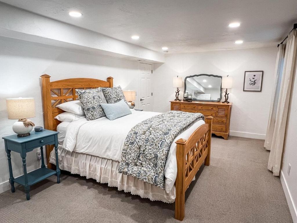 a bedroom with a bed and a dresser and a mirror at Bright & Cozy Basement Retreat in American Fork