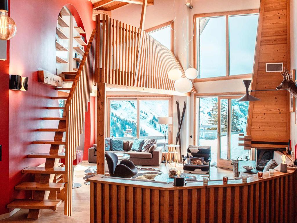 a living room with a spiral staircase in a house at Superbe chalet 5 chambres avec cheminée et accès privatif à Avoriaz - FR-1-314-161 in Morzine