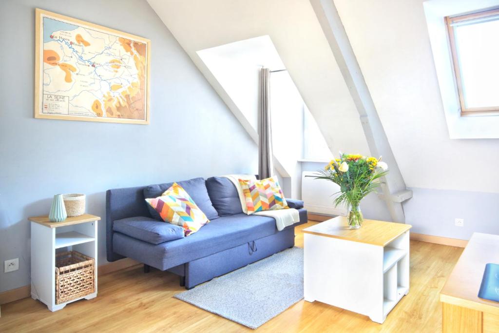 un salon avec un canapé bleu et une table dans l'établissement Louis Philippe - Second Souffle - Cherbourg, à Cherbourg en Cotentin