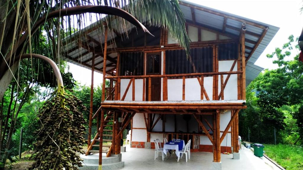 a house under construction with chairs and a tree at Hospedaje piedras de agua in Santa Marta