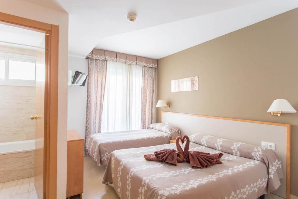 a hotel room with a bed and a dresser at Hotel Cosmos Tarragona in Tarragona