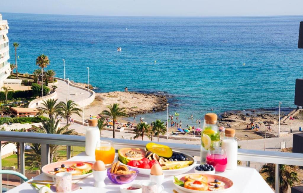 a table with food and a view of the ocean at Playa Salinas Grupo Terra De Mar in Calpe
