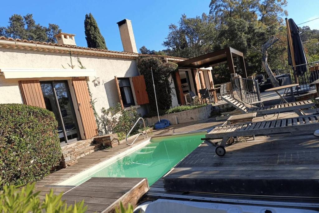 une maison avec une piscine bordée de chaises dans l'établissement Spacious house with pool in Cabasson, à Bormes-les-Mimosas