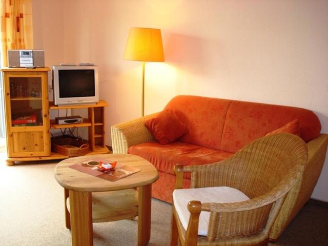 ein Wohnzimmer mit einem Sofa und einem Tisch in der Unterkunft Gespensterwald - Ferienwohnung 24 in Ostseebad Nienhagen