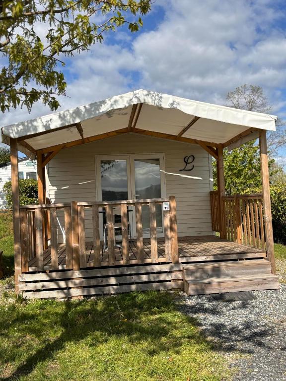 Cette petite maison dispose d'une terrasse couverte et d'un toit. dans l'établissement Le Camping de Ripan, à Bessenay