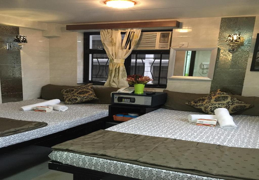 Cette chambre comprend deux lits et un canapé. dans l'établissement Skycity Hostel, à Hong Kong