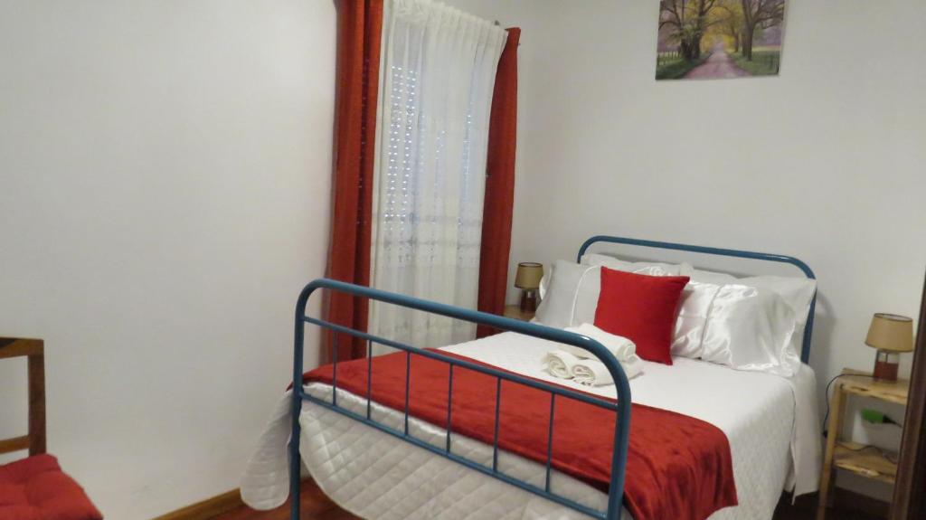 a bedroom with a bed with red and white pillows at Casa da Calçada - Piso 1 in Seia