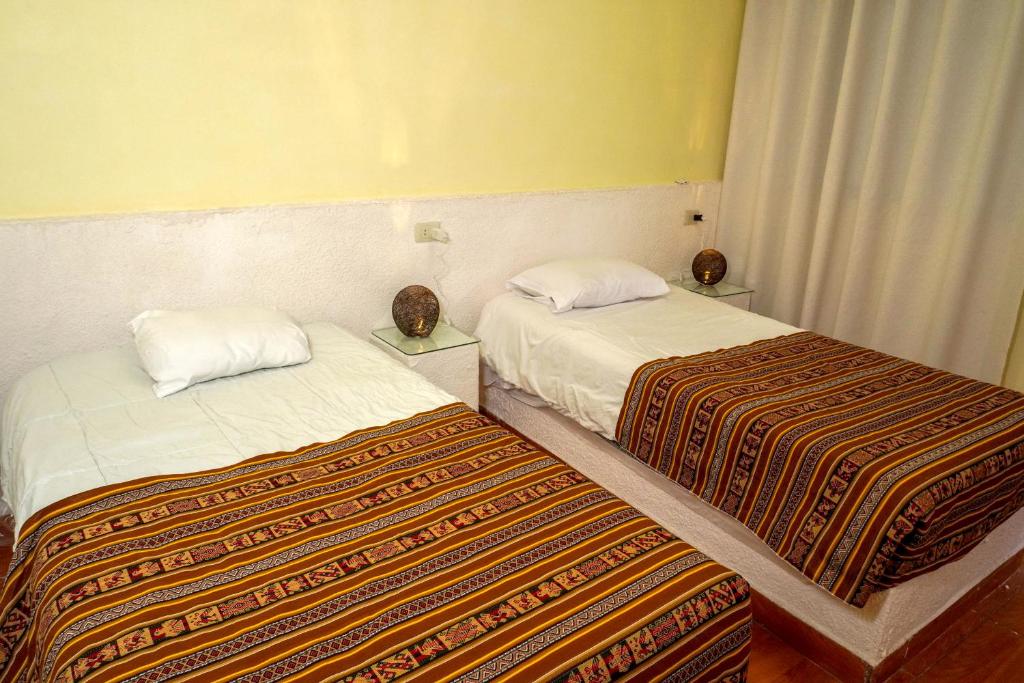 two beds in a hotel room with two at Cabaña Sal y Piedra in Uyuni