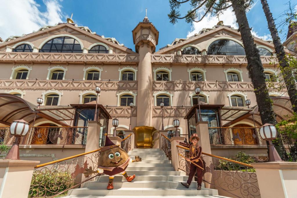 a man standing on the stairs of a building at Chocoland Hotel Gramado in Gramado