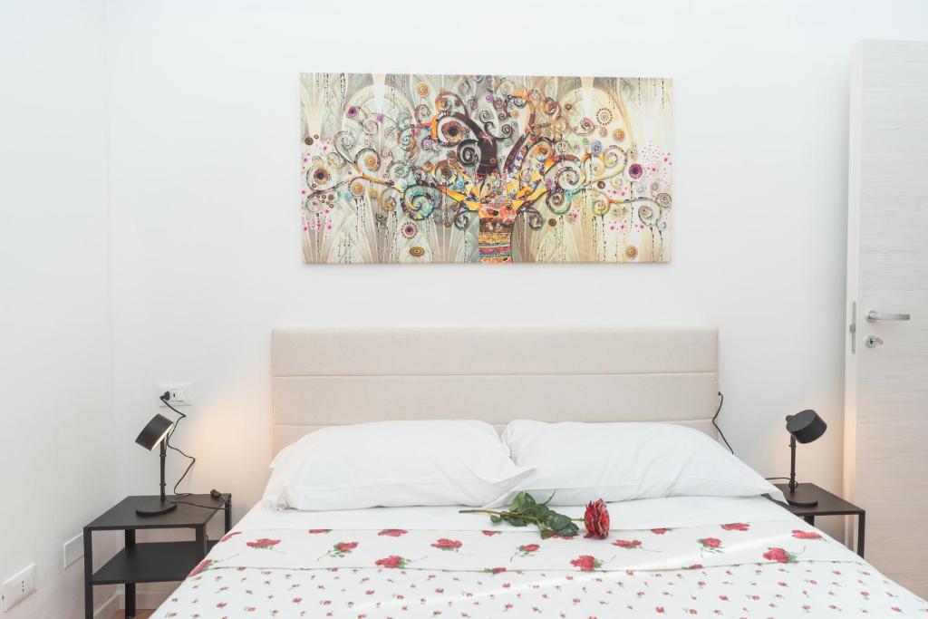 ein Schlafzimmer mit einem Bett und einem Gemälde an der Wand in der Unterkunft Giada 103 - Central Florence Apartment by the train station in Florenz