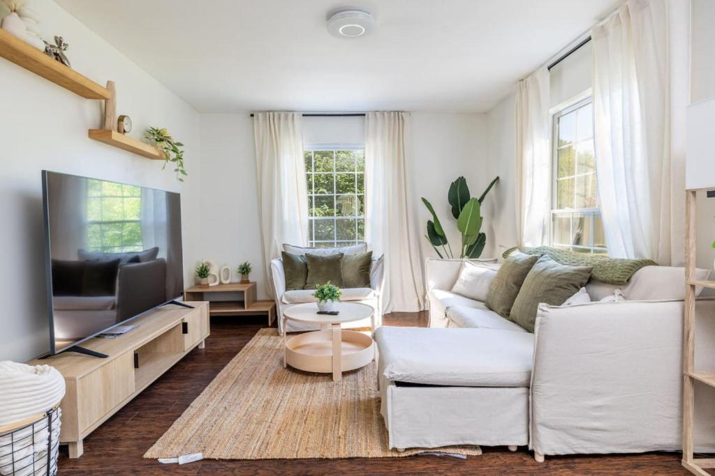 Una sala de estar con muebles blancos y un televisor de pantalla plana. en Cozy Duplex w King Bed 2 Full, en Maryville