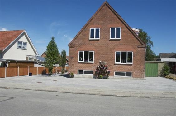 a large brick house in a parking lot at Ikast Bed & Kitchen in Ikast