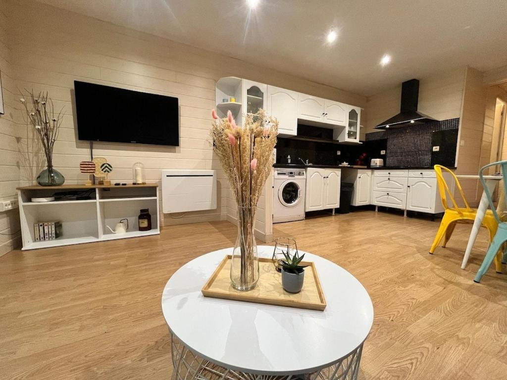 une cuisine avec une table avec un vase de fleurs dessus dans l'établissement Alonville 2pers Wifi and Tv, à Nantes