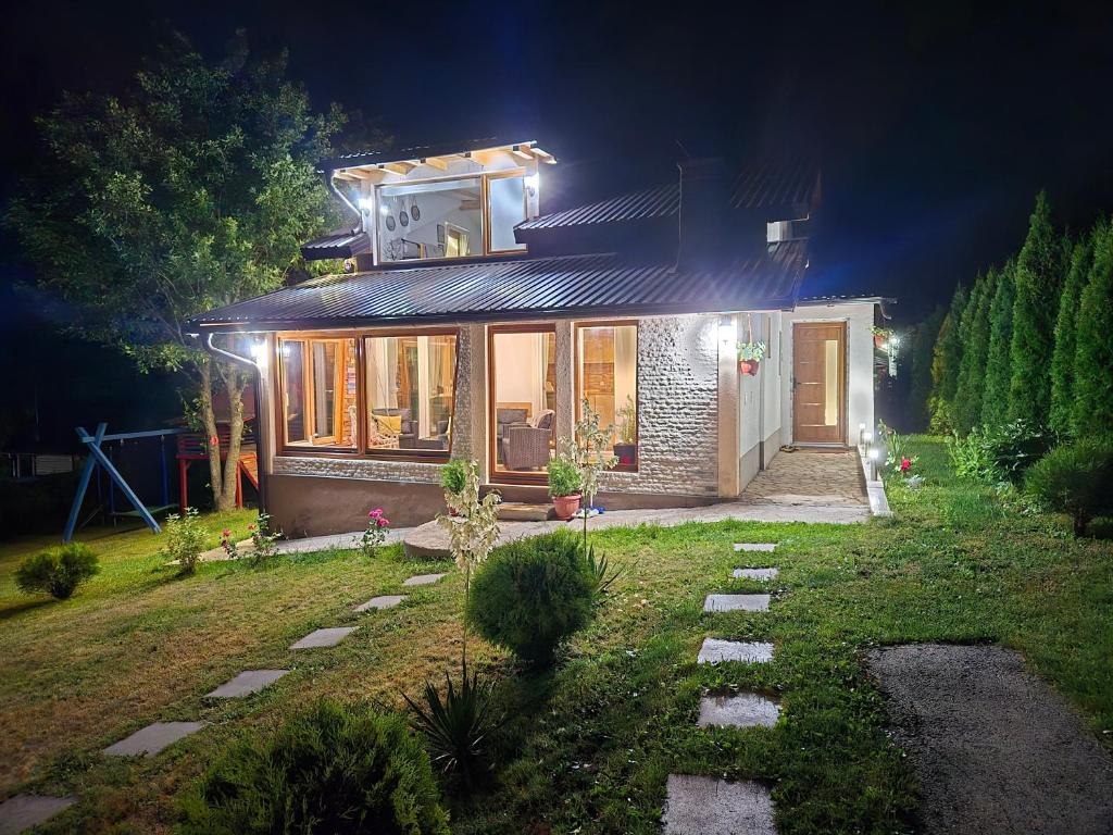 a small house with a light on the roof at night at Mountain House Brutusi 17 Bjelasnica Trnovo BIH in Trnovo