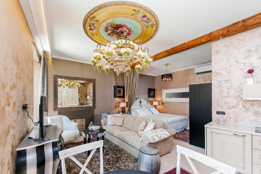 a living room with a bed and a chandelier at Apartment Piazza in Rovinj