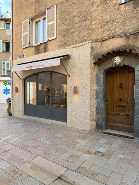 un magasin avec une porte en bois sur un bâtiment dans l'établissement Charmant studio cœur de ville Saint Tropez, à Saint-Tropez