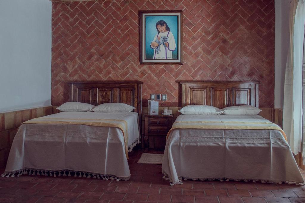 two beds sitting next to each other in a room at Hotel Casa Mixteca in Huajuapan de León