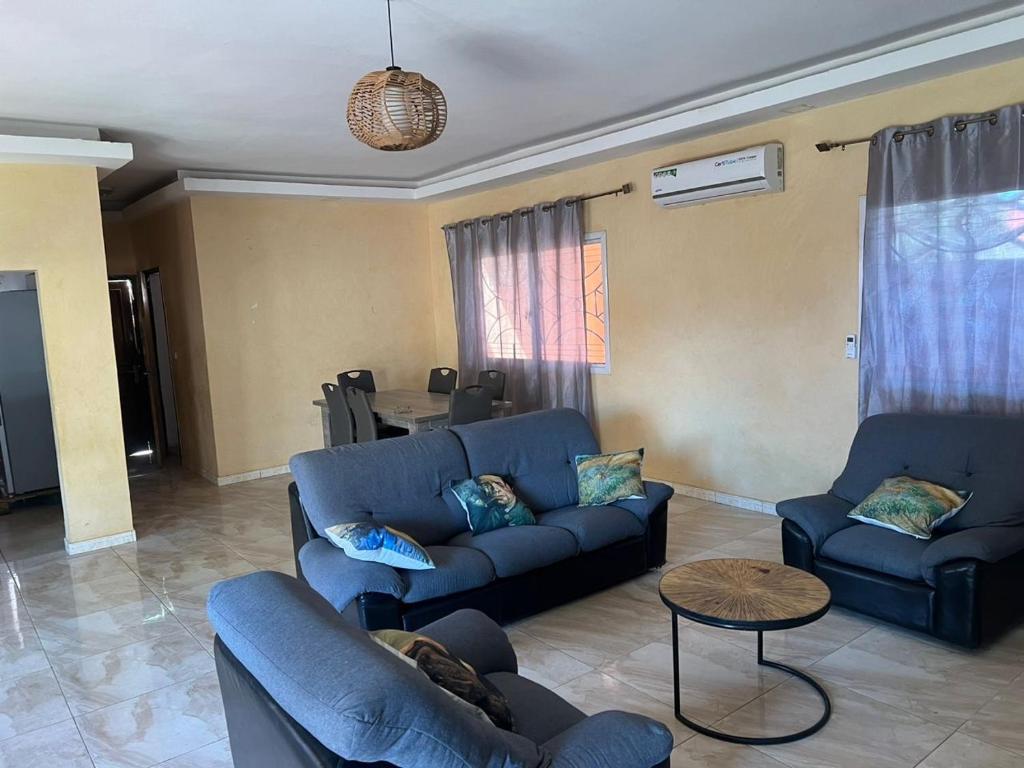 a living room with two blue couches and a table at Villa koti koti in Ngaparou