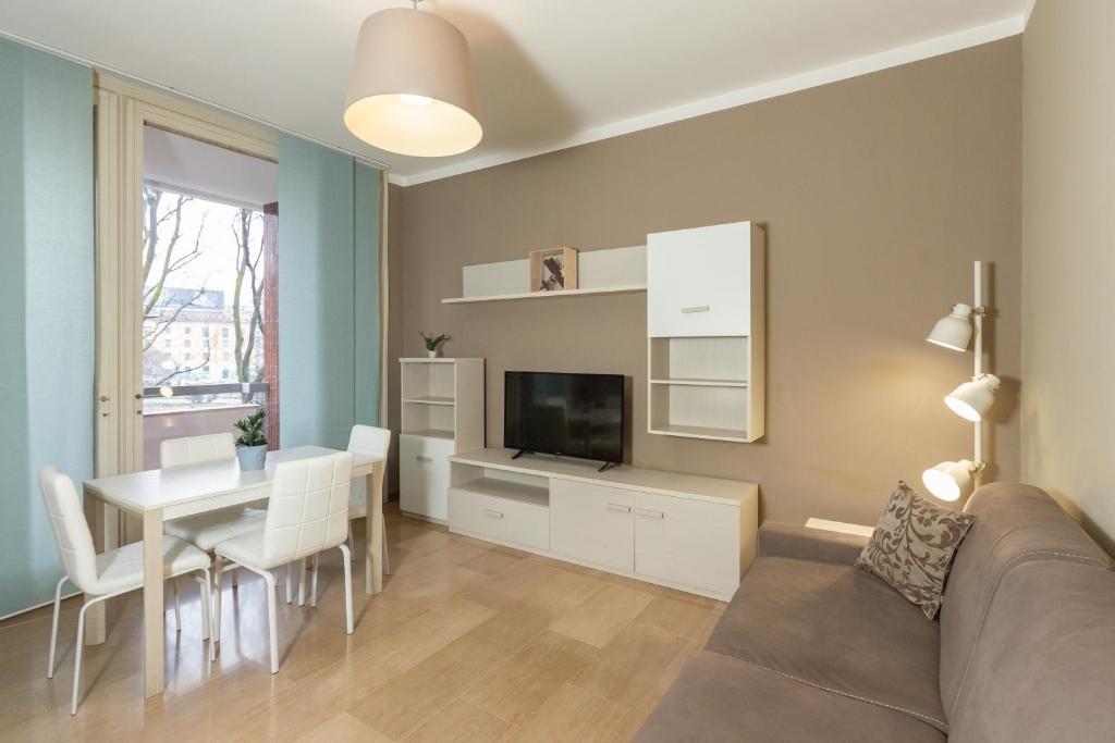 a living room with a couch and a table with a television at Honey Exclusive Apartment - Train Station - Near Center in Milan