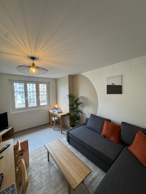 un salon avec un canapé bleu et une table dans l'établissement L'alpin, coeur de grenoble, à Grenoble